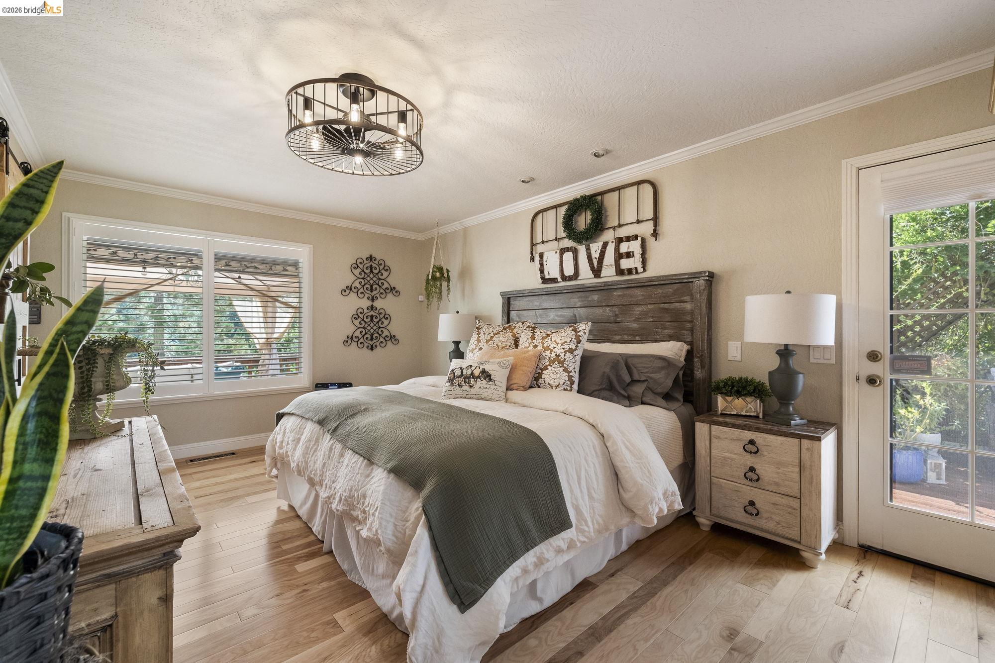 20581 Gerber Road Tuolumne, CA 95379 - Photo 3 of 60 Bedroom with crown molding, access to outside, light wood-style floors, and a chandelier