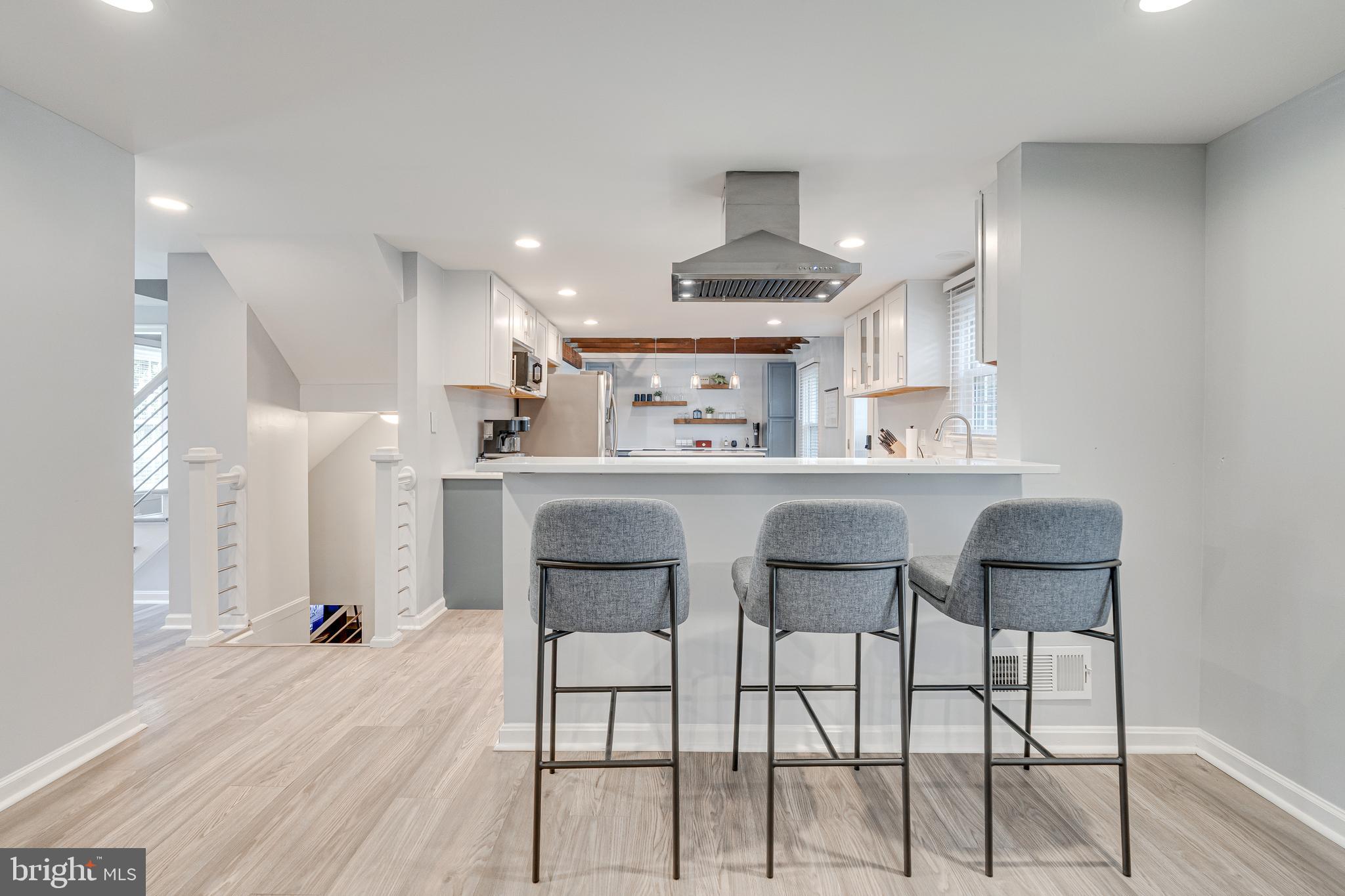 8501 Aqueduct Road Potomac, MD 20854 - Photo 12 of 54 a kitchen with kitchen island stainless steel appliances a table chairs refrigerator and microwave