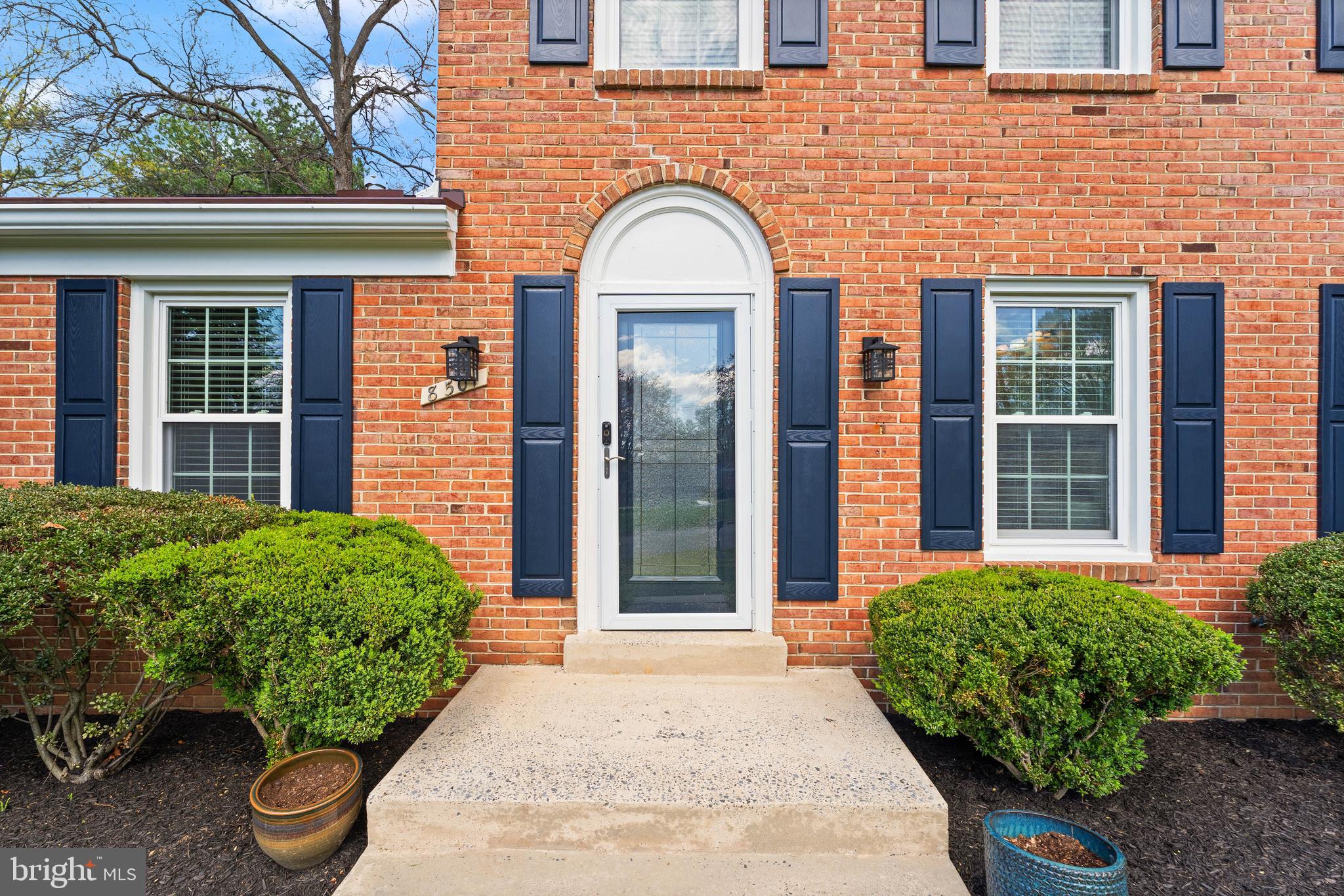 8501 Aqueduct Road Potomac, MD 20854 - Photo 4 of 54 a view of a brick house with potted plants