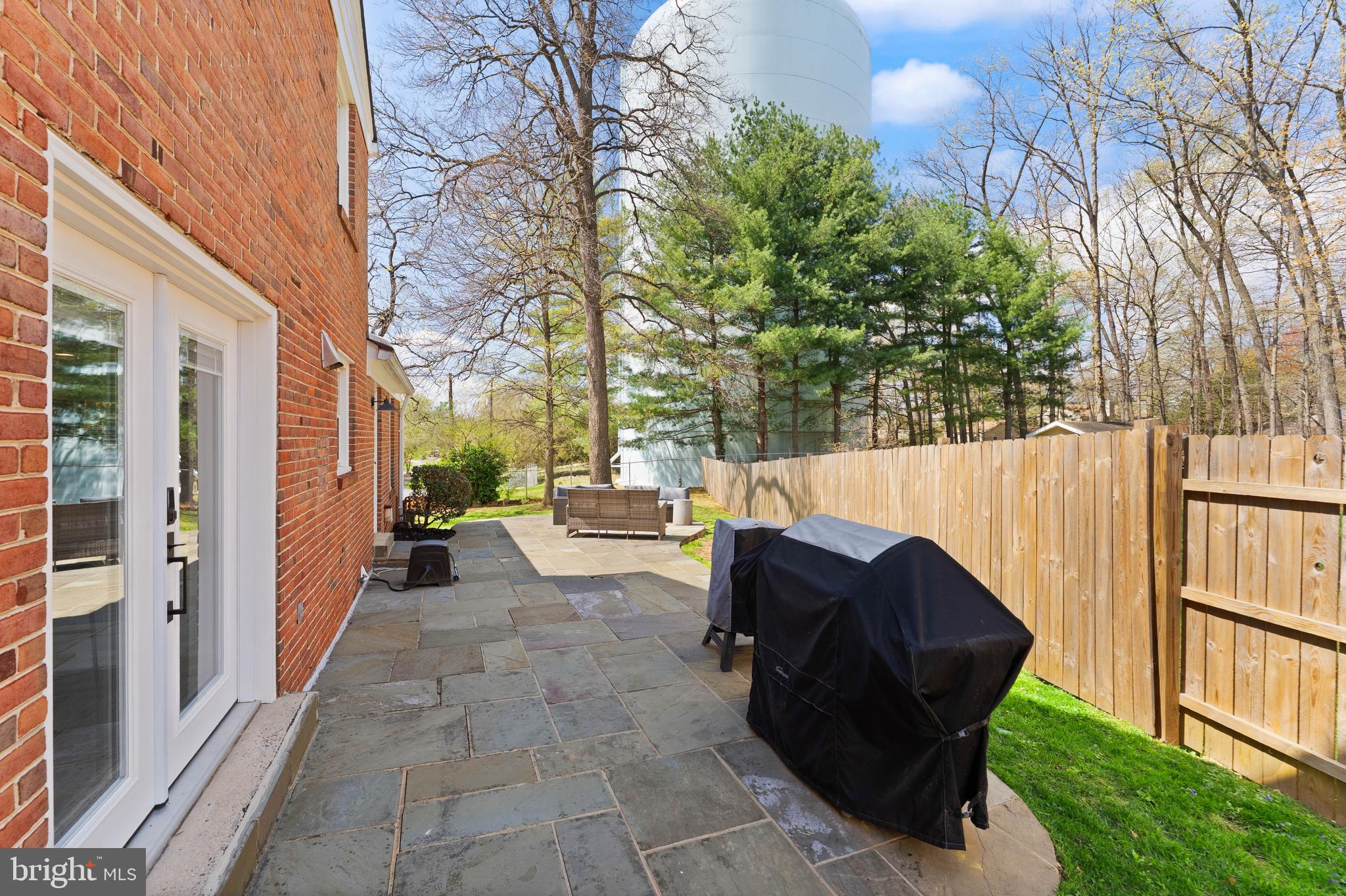 8501 Aqueduct Road Potomac, MD 20854 - Photo 42 of 54 a view of a patio with table and chairs and couches with wooden fence and plants