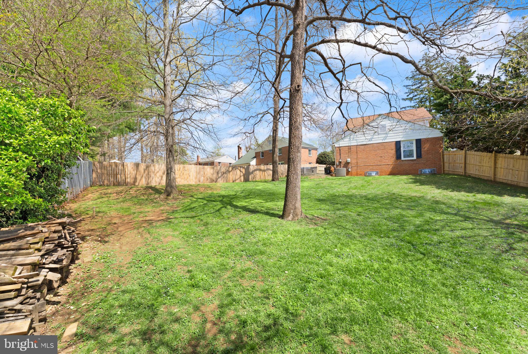 8501 Aqueduct Road Potomac, MD 20854 - Photo 48 of 54 a backyard of a house with large trees and a small yard