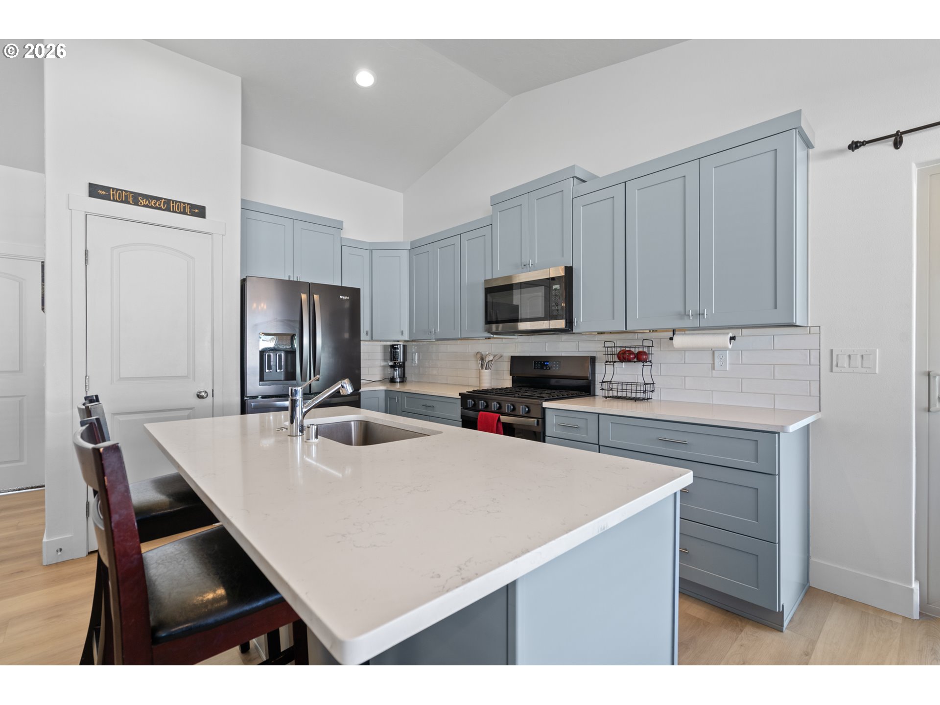 306 Sage Street Boardman, OR 97818 - Photo 4 of 24 a kitchen with kitchen island a stove a sink a microwave a refrigerator a dining table and chairs