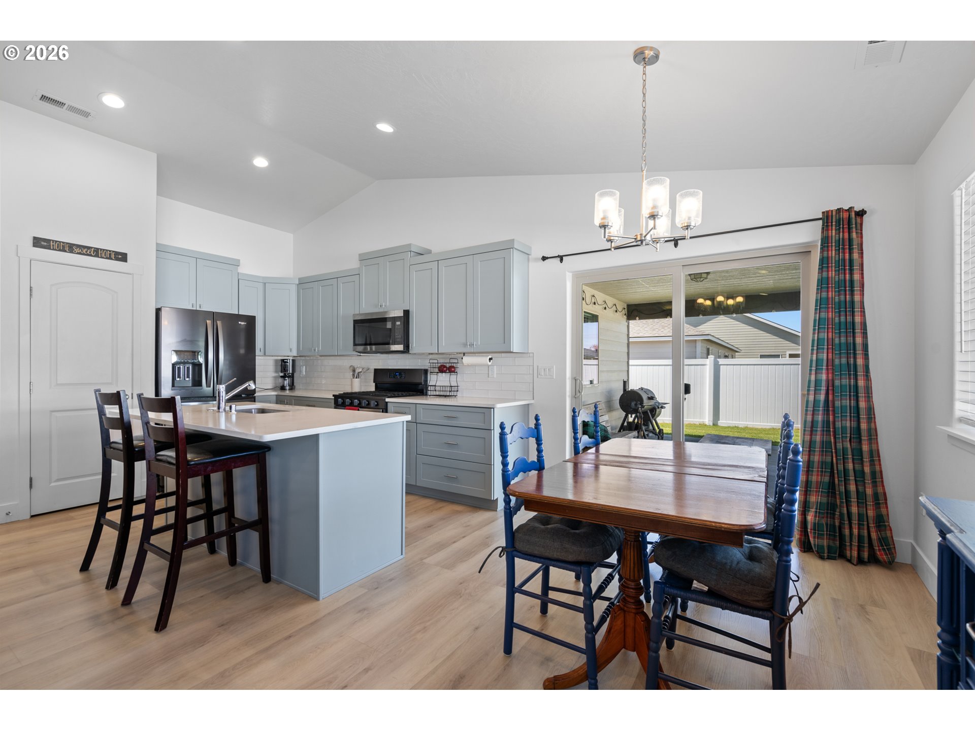 306 Sage Street Boardman, OR 97818 - Photo 5 of 24 a kitchen with kitchen island a dining table chairs and white cabinets