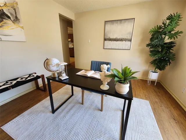 a view of a workspace with furniture and wooden floor