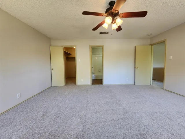 a view of an empty room with a ceiling fan