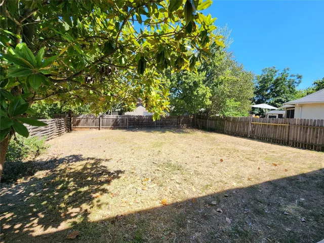 a view of yard with wooden fence