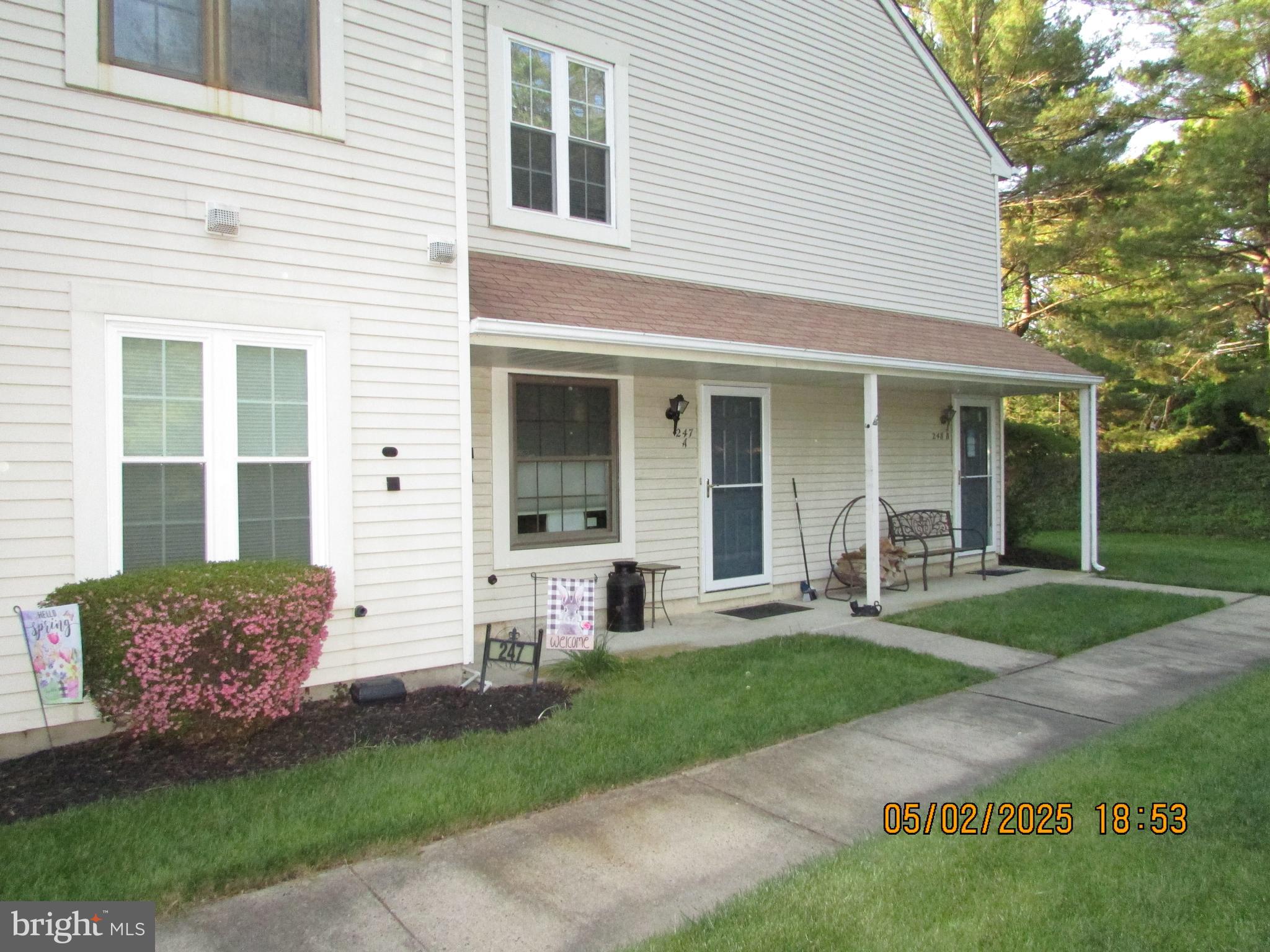 a front view of a house with a yard and plants