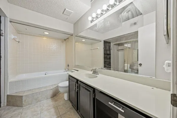 a bathroom with a sink a large mirror and a bathtub