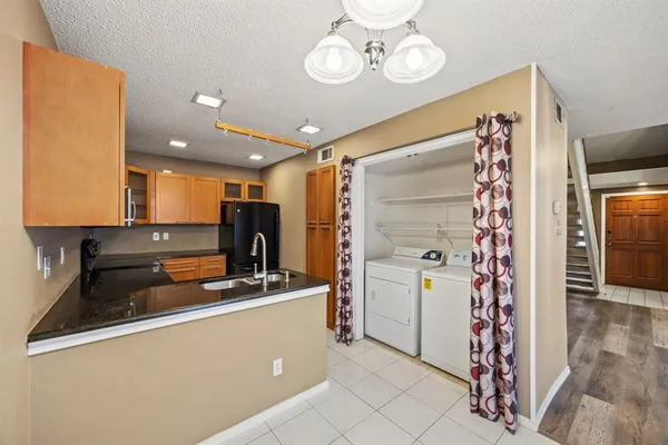 a kitchen with stainless steel appliances granite countertop a refrigerator and a sink