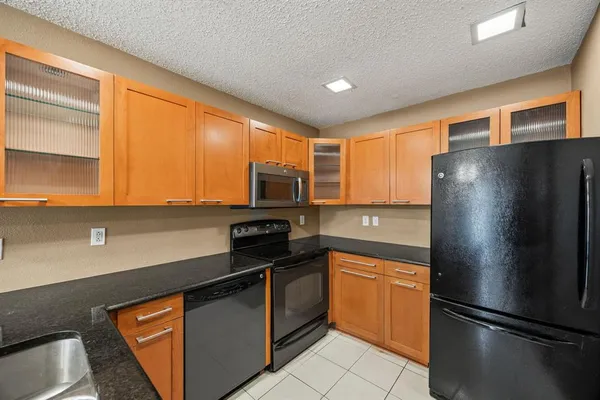 a kitchen with stainless steel appliances granite countertop a refrigerator and a stove top oven
