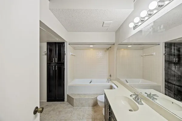 a bathroom with a tub a sink and a large mirror