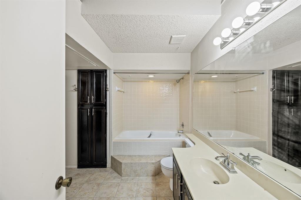 559 Ranch Trail, Unit 213 Irving, TX 75063 - Photo 10 of 18 a bathroom with a tub a sink and a large mirror