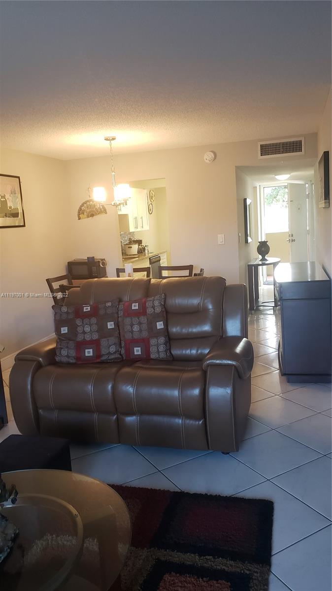 3120 North Pine Island Road, Unit 203 Sunrise, FL 33351 - Photo 5 of 8 a living room with furniture and a potted plant
