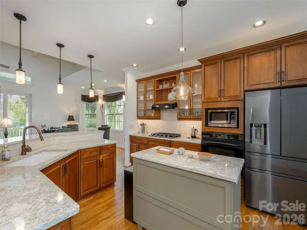a kitchen with stainless steel appliances granite countertop a sink a stove and a refrigerator