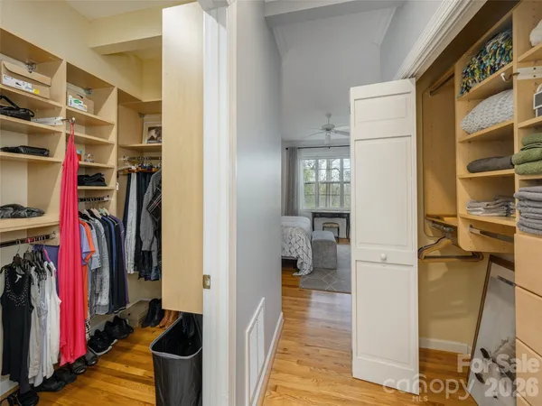 a view of walk in closet with clothes and shoes