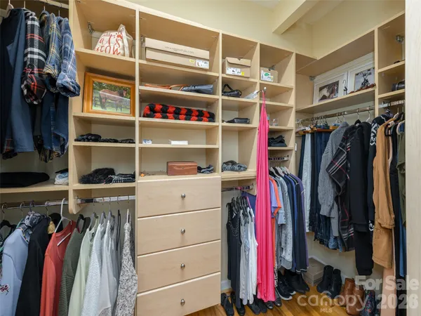 a view of walk in closet with clothes and shoes