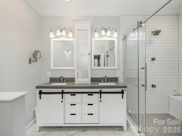 a bathroom with a double vanity sink mirror and shower