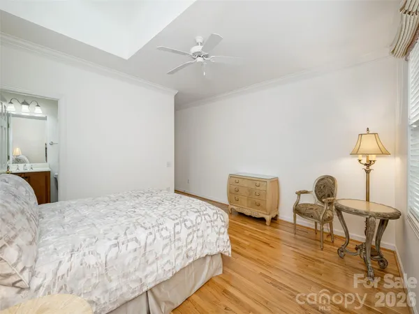 a bedroom with a bed and a table with wooden floor