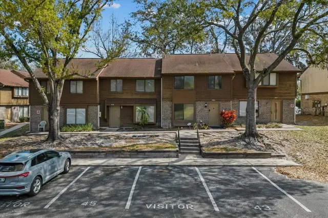 a view of a house with street that has a tree