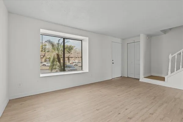 a view of an empty room with a window and closet area