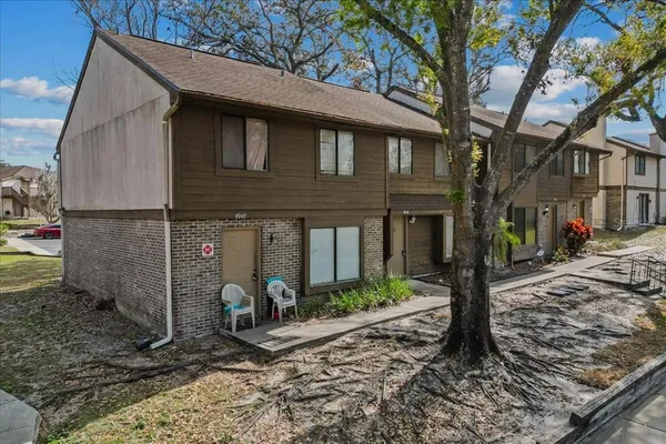 a view of a house with a yard and tree s