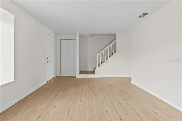 a view of an empty room with wooden floor