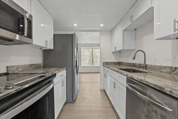 a kitchen with stainless steel appliances granite countertop a stove and a sink