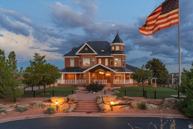 5615 East Eight Mile Gap Road Kanab, UT 84741 - Photo 65 of 81 Victorian house with covered porch, a fenced front yard, and brick siding