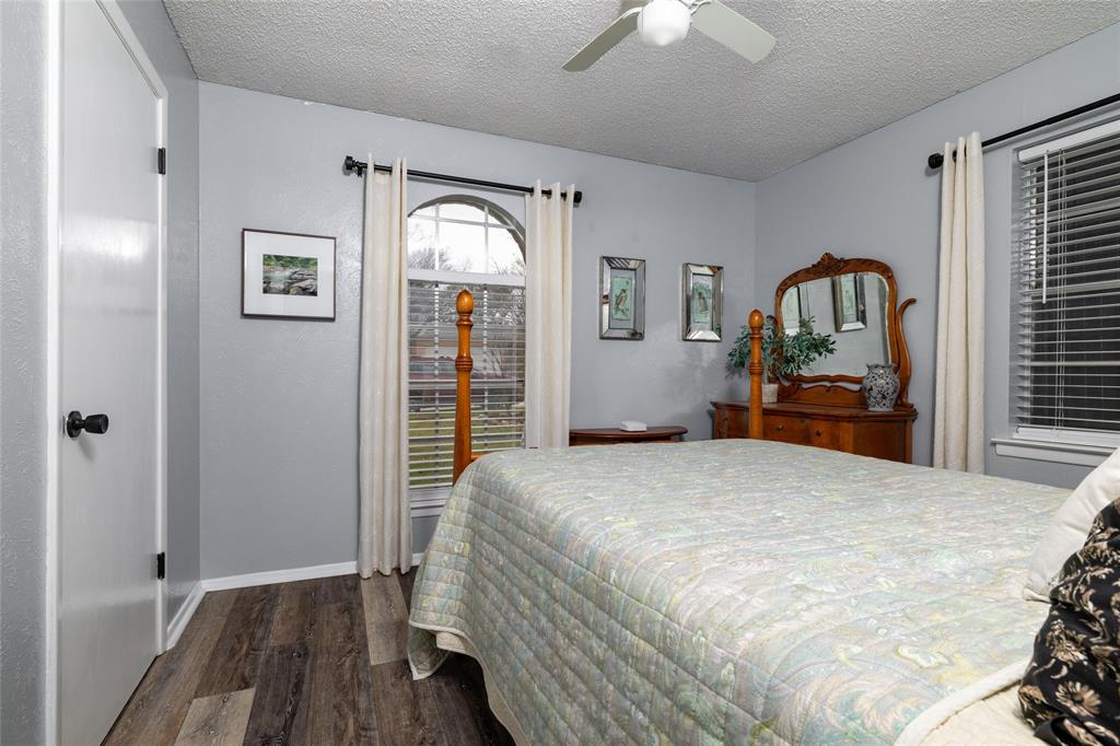 6020 Harrison Way Watauga, TX 76148 - Photo 27 of 32 Bedroom with a textured ceiling, dark wood finished floors, and ceiling fan