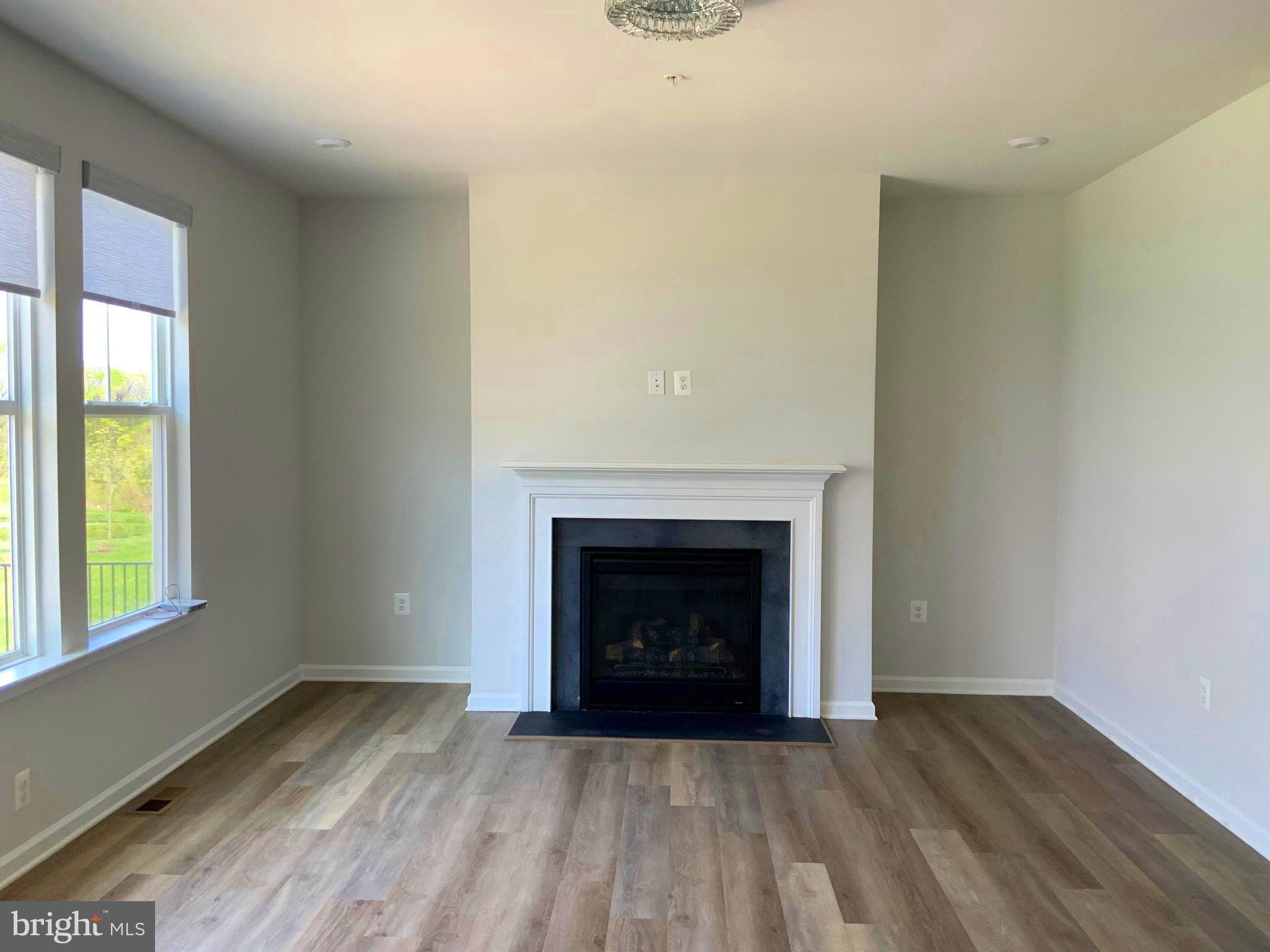 5763 Hawk Ridge Road Frederick, MD 21704 - Photo 11 of 73 a view of an empty room with wooden floor fireplace and a window