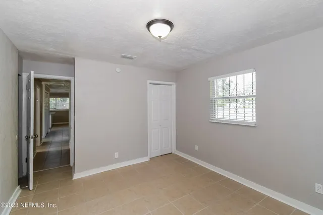 an empty room with windows and closet