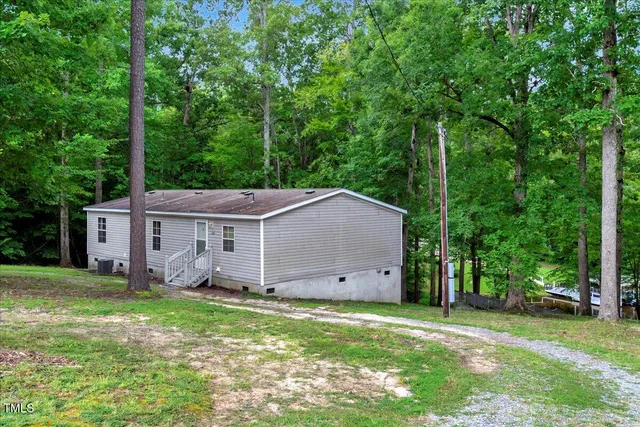 front view of a house with a big yard and large trees