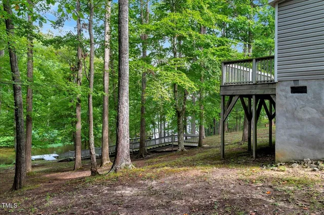 a view of a house with backyard and trees