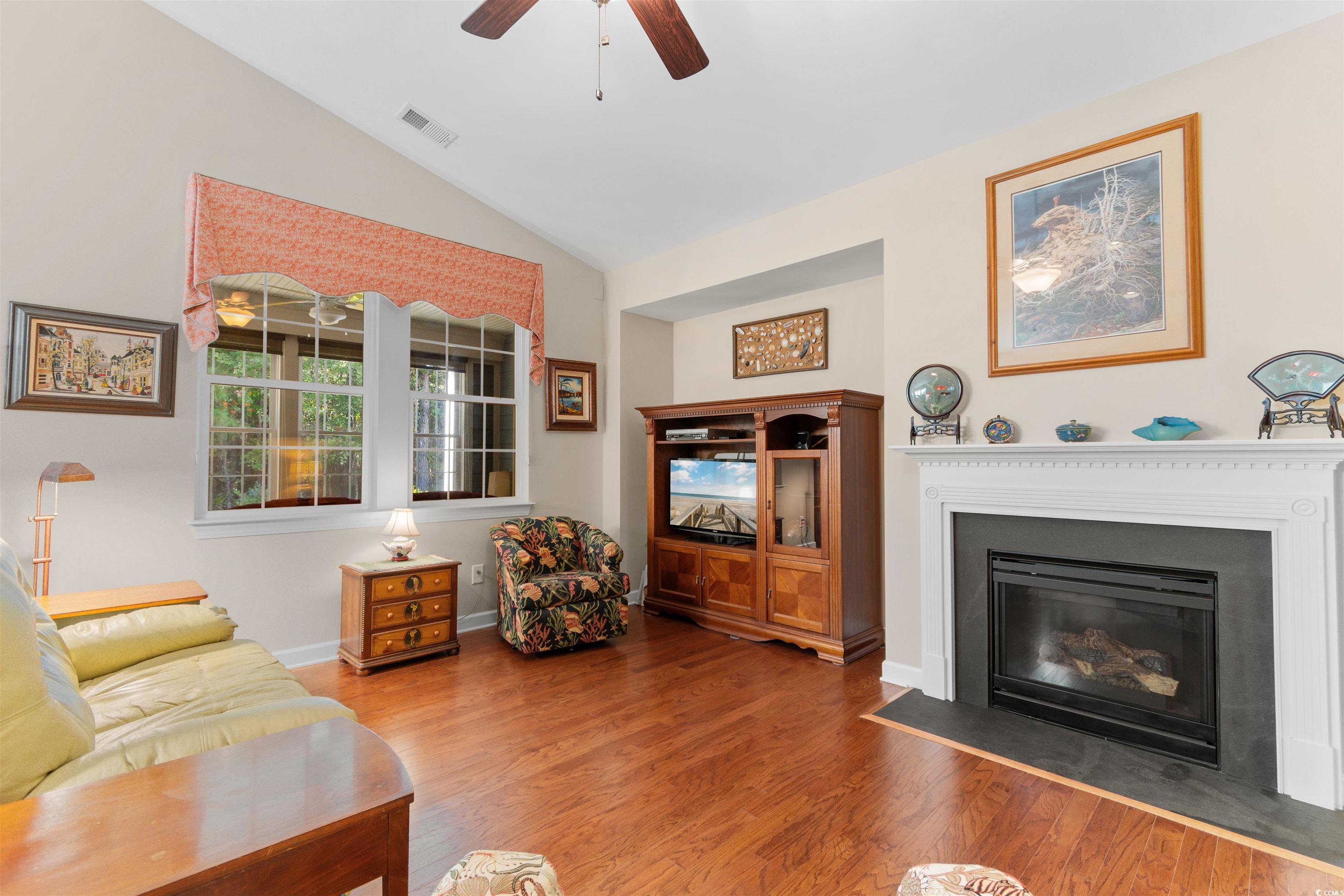 1573 Culbertson Avenue Myrtle Beach, SC 29577 - Photo 12 of 40 Living room with vaulted ceiling, wood finished floors, a fireplace with flush hearth, and ceiling fan