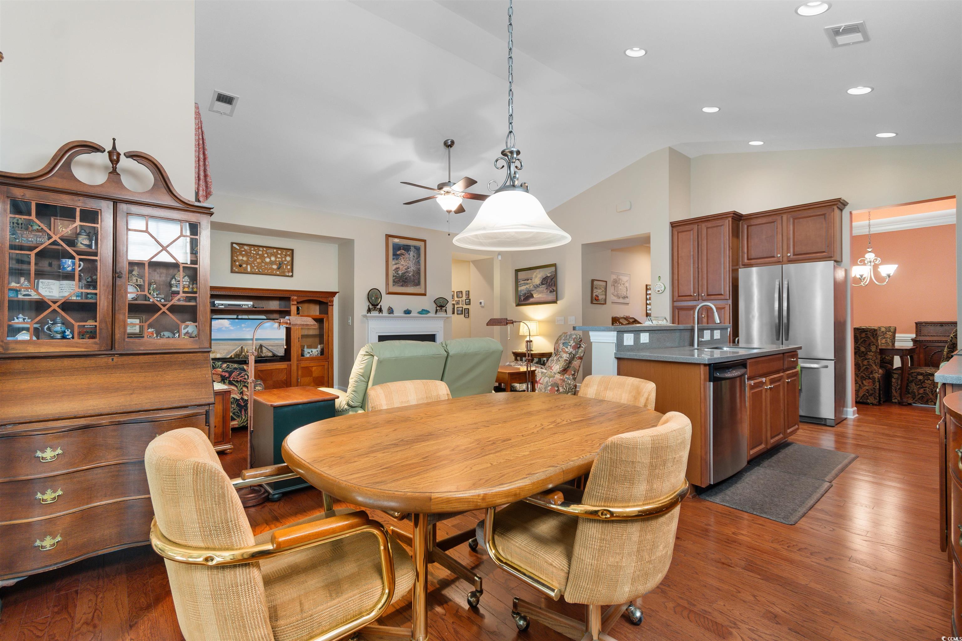 1573 Culbertson Avenue Myrtle Beach, SC 29577 - Photo 9 of 40 Dining room featuring vaulted ceiling, a ceiling fan, dark wood-style flooring, a chandelier, and a fireplace