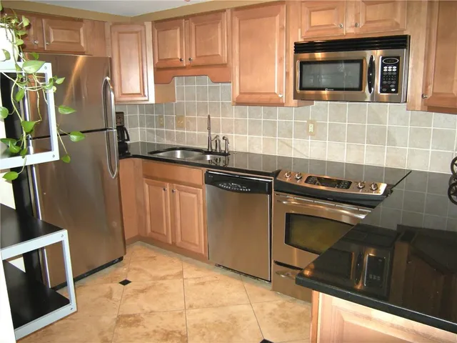 a kitchen with granite countertop a stove top oven microwave and cabinets