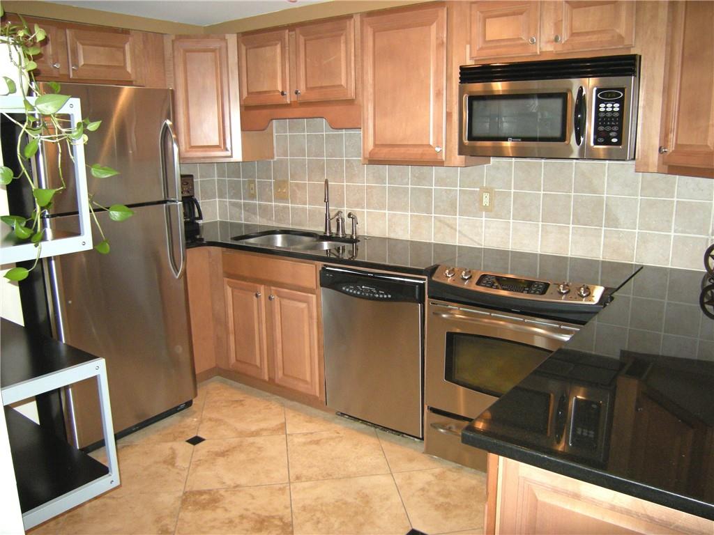 199 14th Street Northeast, Unit 510 Atlanta, GA 30309 - Photo 12 of 21 a kitchen with granite countertop a stove top oven microwave and cabinets