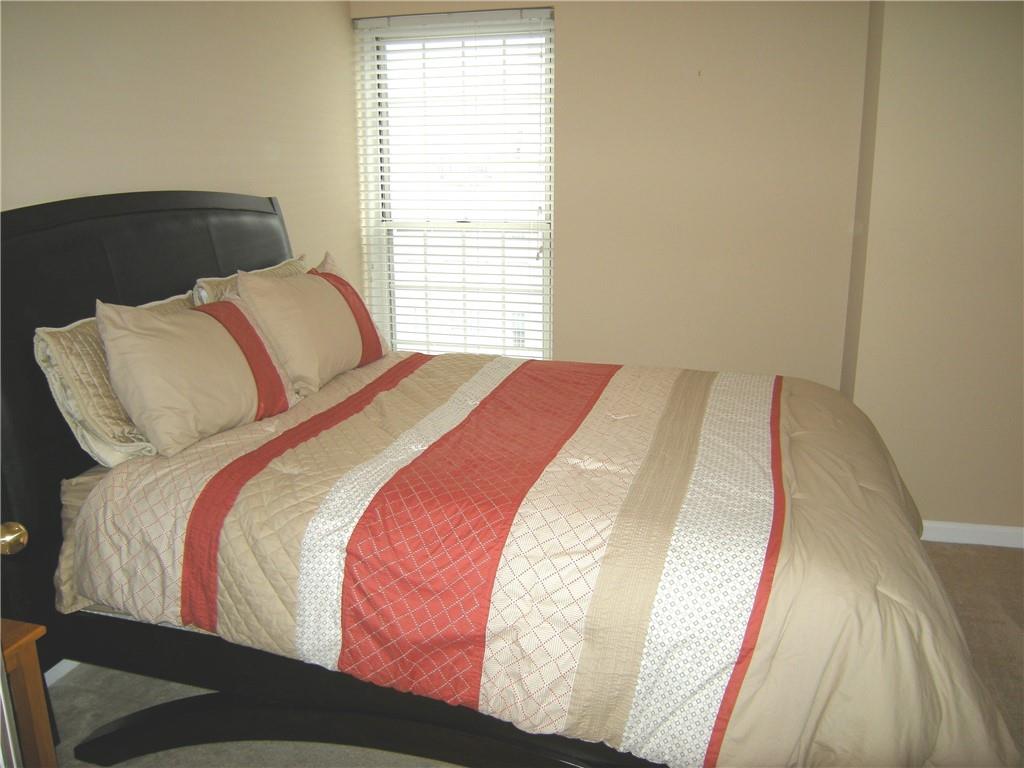 199 14th Street Northeast, Unit 510 Atlanta, GA 30309 - Photo 13 of 21 a bed sitting in a bedroom next to a window