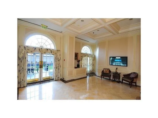 a living room with furniture a flat screen tv and a large window
