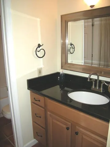a bathroom with a granite countertop sink and a mirror