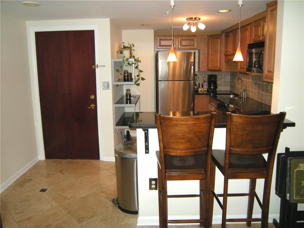 199 14th Street Northeast, Unit 510 Atlanta, GA 30309 - Photo 5 of 21 a kitchen with stainless steel appliances kitchen island granite countertop a refrigerator and a sink