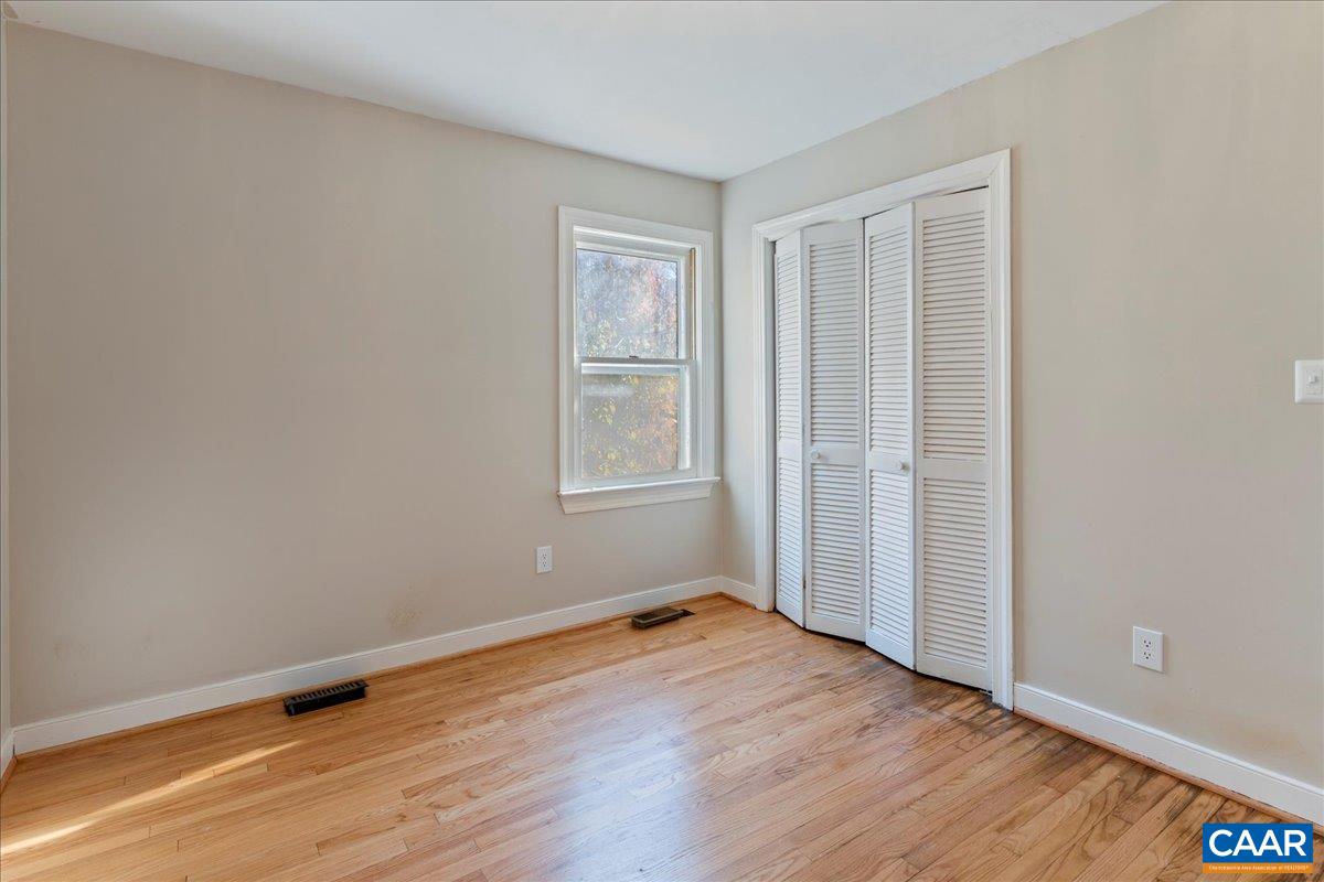 555 Gillums Ridge Road Charlottesville, VA 22903 - Photo 28 of 66 an empty room with wooden floor and windows