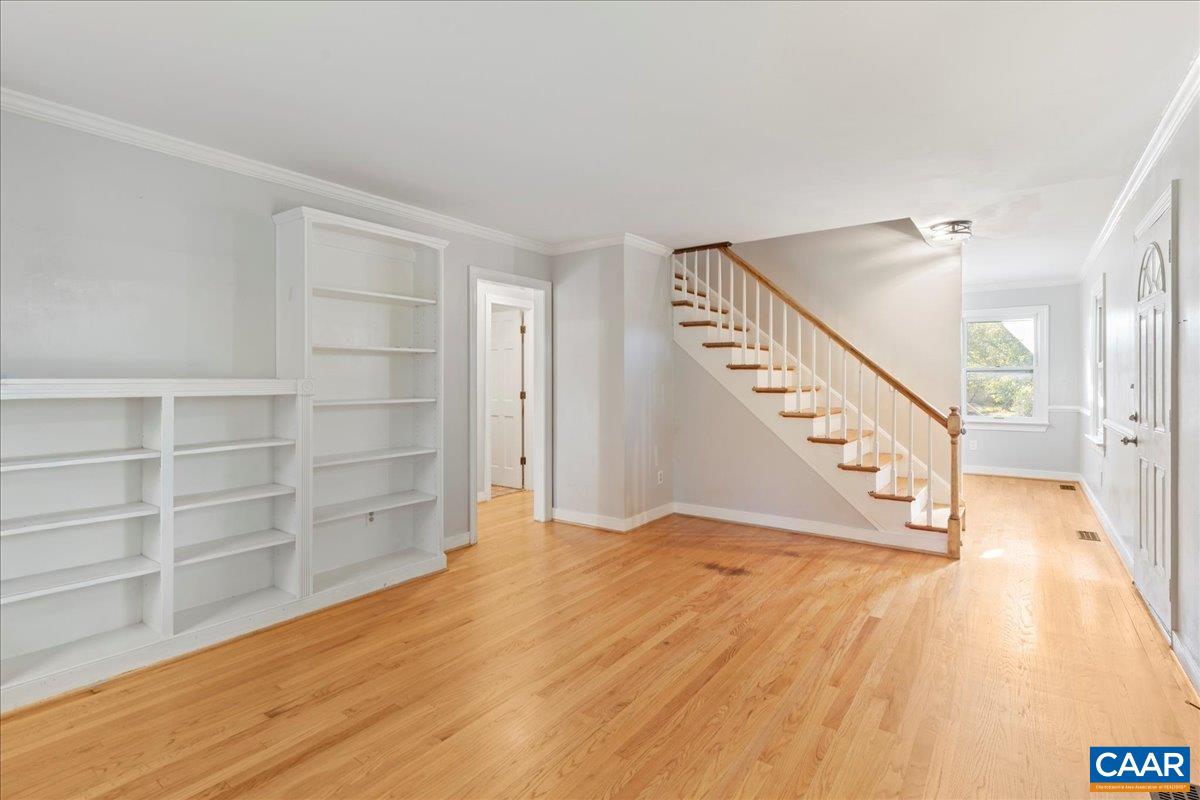 555 Gillums Ridge Road Charlottesville, VA 22903 - Photo 10 of 66 a view of an empty room with wooden floor and stairs