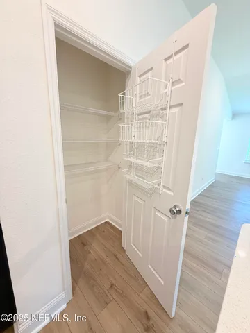 a view of a hallway with wooden floor and entryway