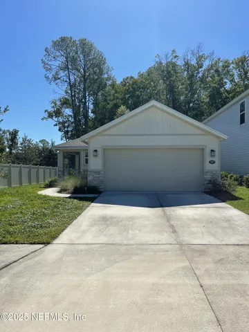 a front view of a house with a yard and trees