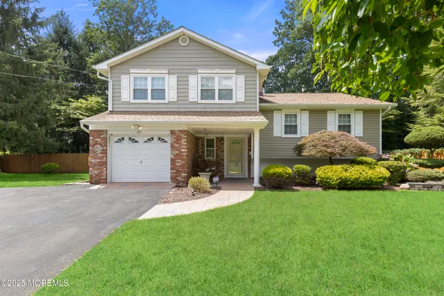 a front view of a house with a garden and yard