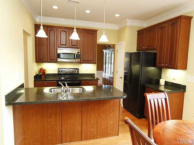 3805 Cathedral Bell Road Raleigh, NC 27614 - Photo 7 of 24 Set the mood with the super upgraded lighting package in your kitchen: Recessed, pendulum, under cabinet. Note the crown moldings even in your kitchen. Extra deep stainless steel sinks, granite, overhang for bar stools if you like.
