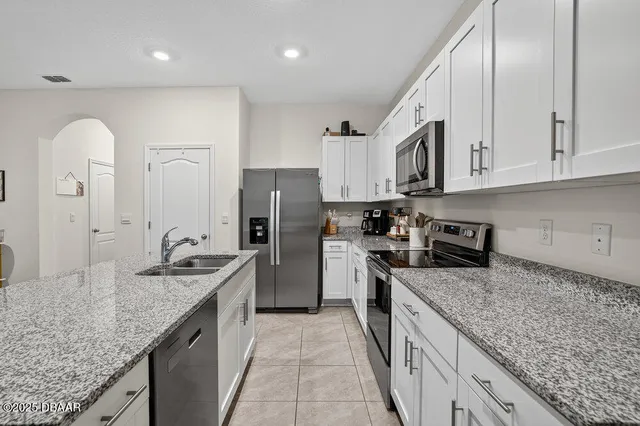 a kitchen with stainless steel appliances granite countertop a sink a stove and a refrigerator