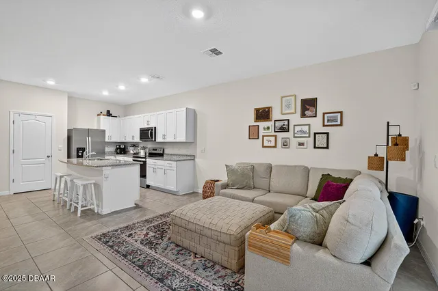 a living room with furniture and kitchen view