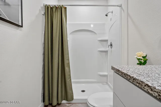 a bathroom with a granite countertop sink toilet and shower
